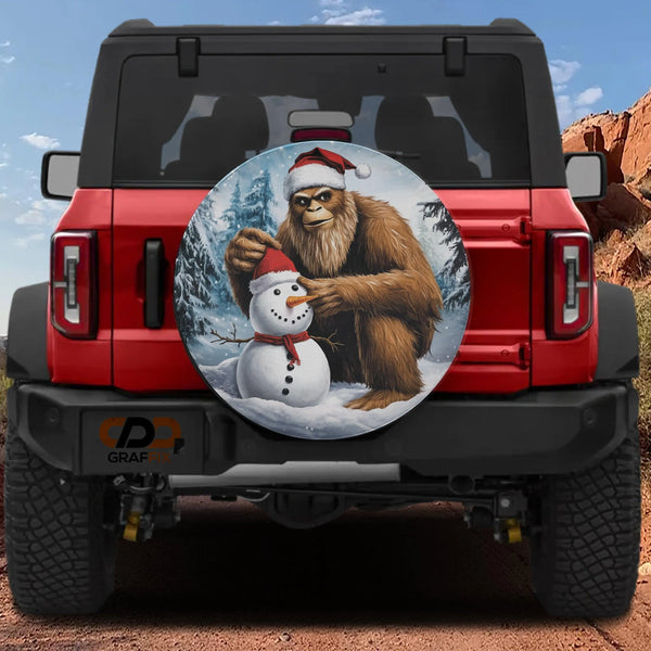Sasquatch Holiday Tire Cover, Bigfoot Building Snowman Spare Tire Cover, Humorous Winter Scene Wheel Cover, Christmas Present